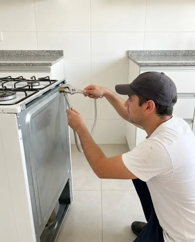 Gasista conectando una cocina a la llave de paso de gas